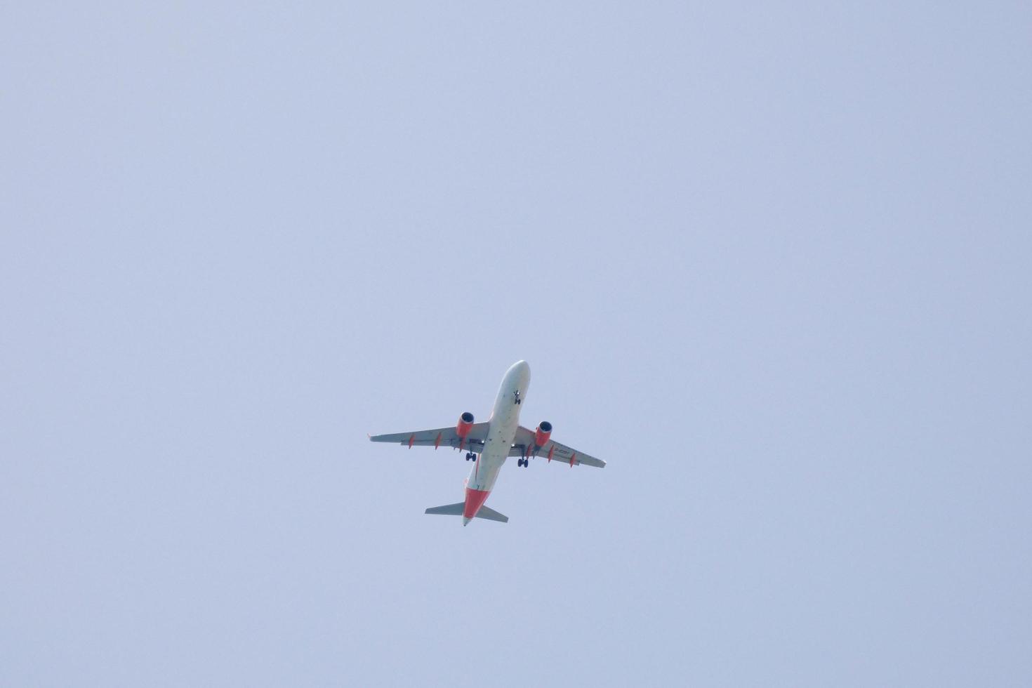 kommersiell flygplan flygande under blå himmel och anländer på de flygplats foto