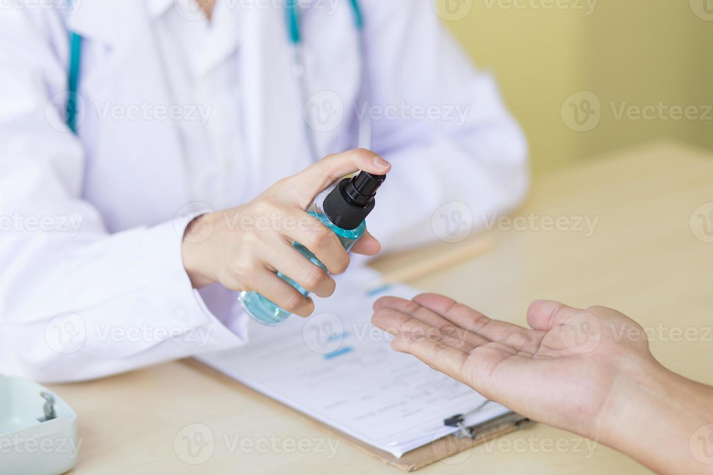coronavirus skydd koncept. kvinnlig läkares hand använder en alkoholspray. foto