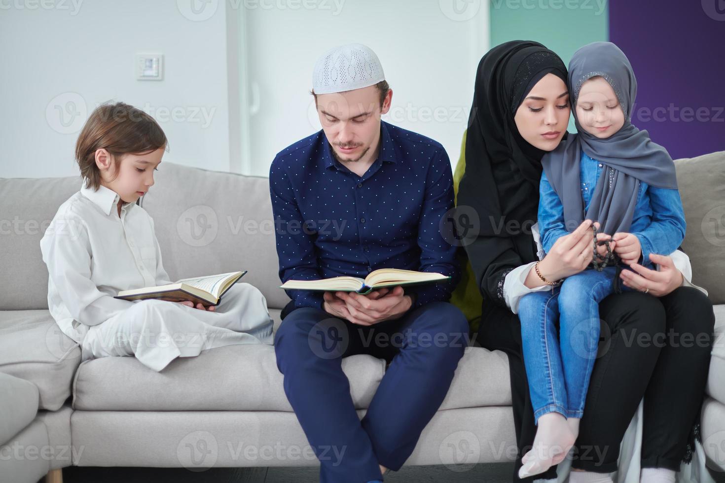 ung muslim familj läsning quran under ramadan foto