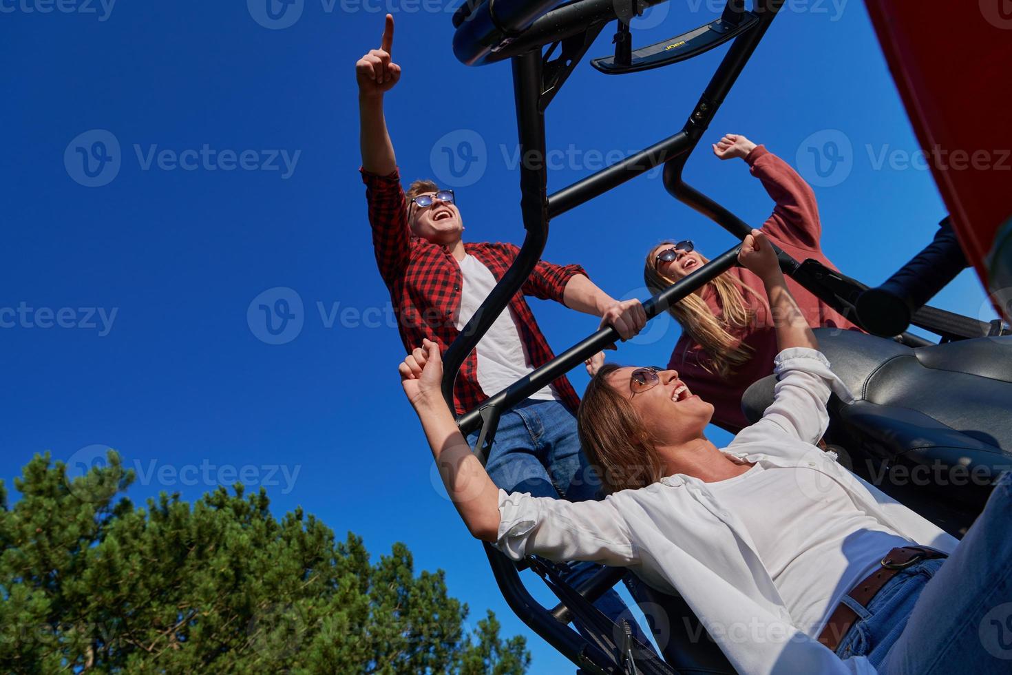 grupp ung Lycklig människor njuter skön solig dag medan körning en av väg buggy bil foto