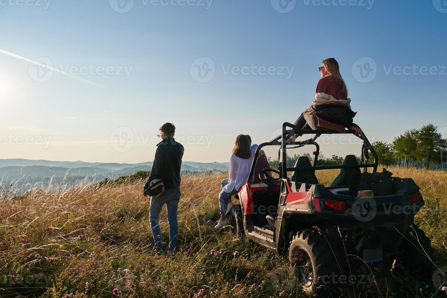 grupp ung Lycklig människor njuter skön solig dag medan körning en av väg buggy bil foto