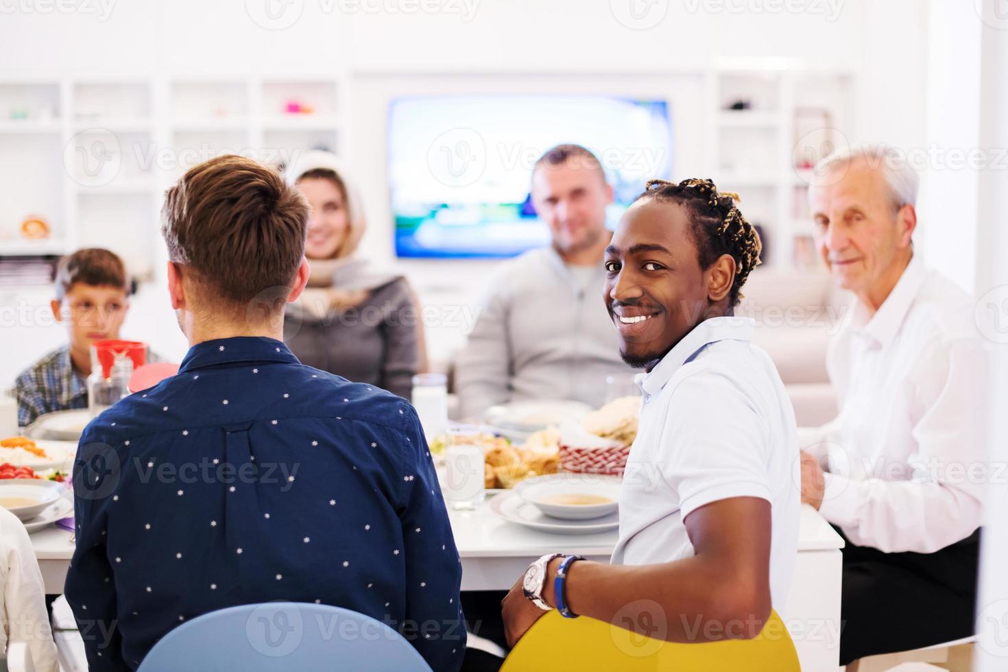 svart man njuter iftar middag med familj foto