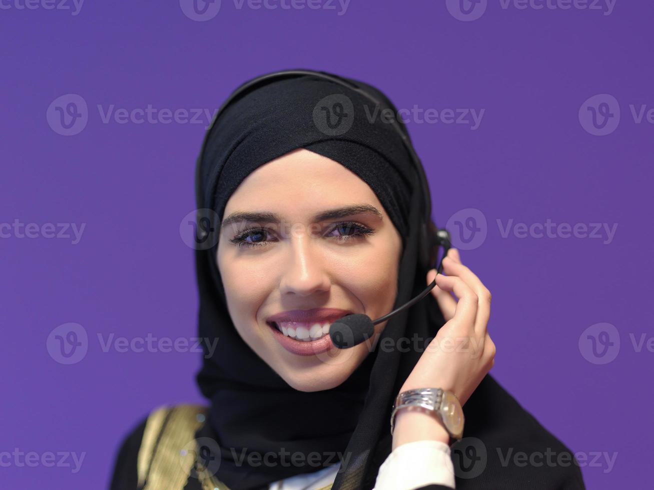 porträtt av muslim kvinna med headsetet på lila bakgrund foto
