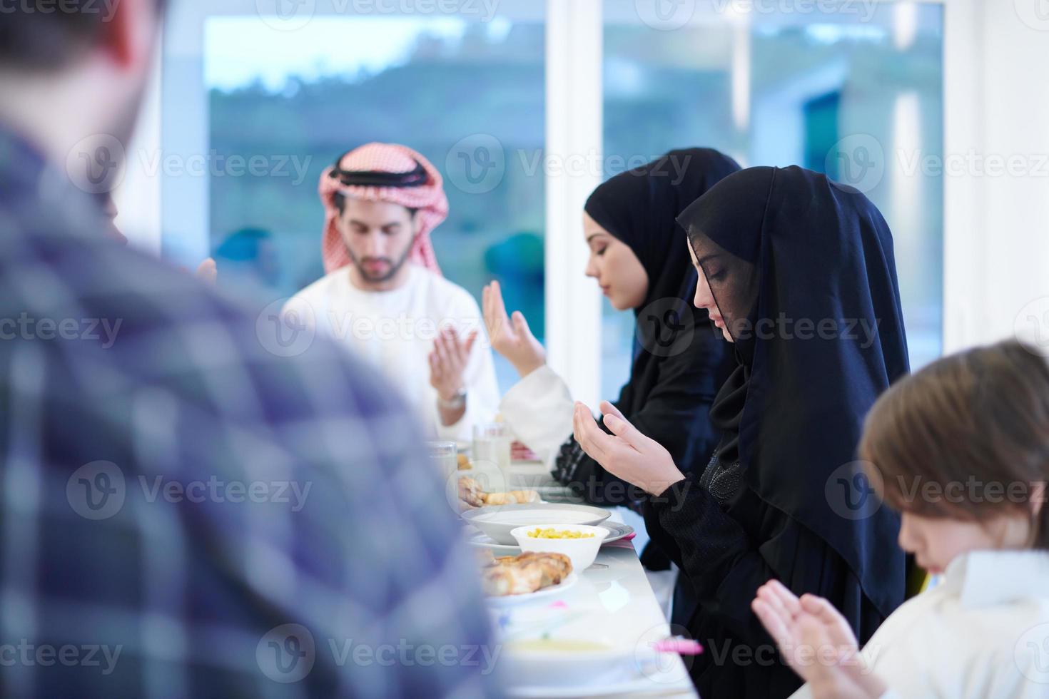 traditionell muslim familj bön- innan iftar middag foto