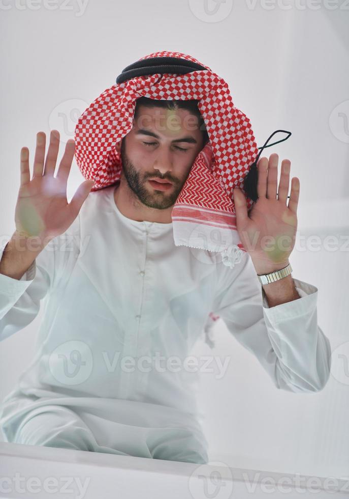 muslim man håller på med sujud eller sajdah på de glas golv foto