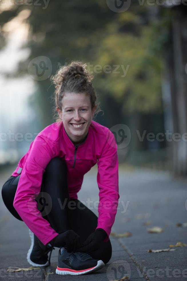 kvinna stretching innan morgon- joggning foto