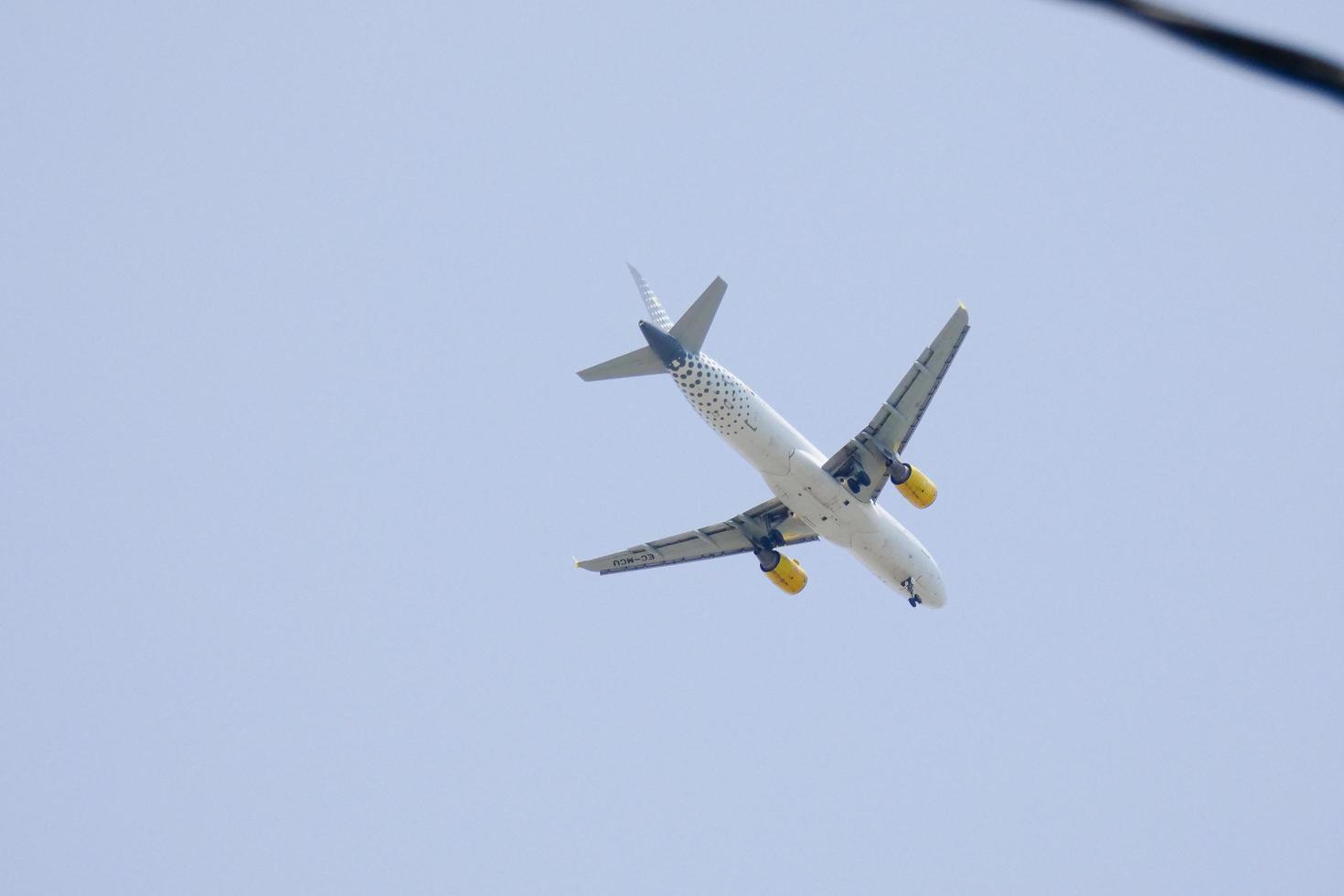 kommersiell flygplan flygande under blå himmel och anländer på de flygplats foto