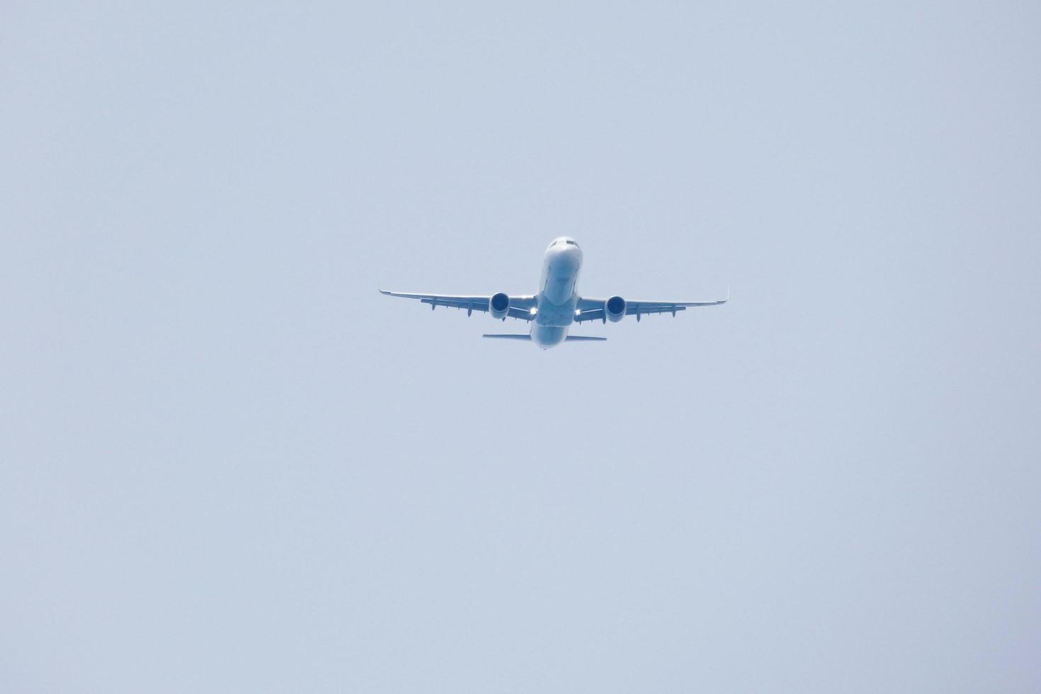 kommersiell flygplan flygande under blå himmel och anländer på de flygplats foto