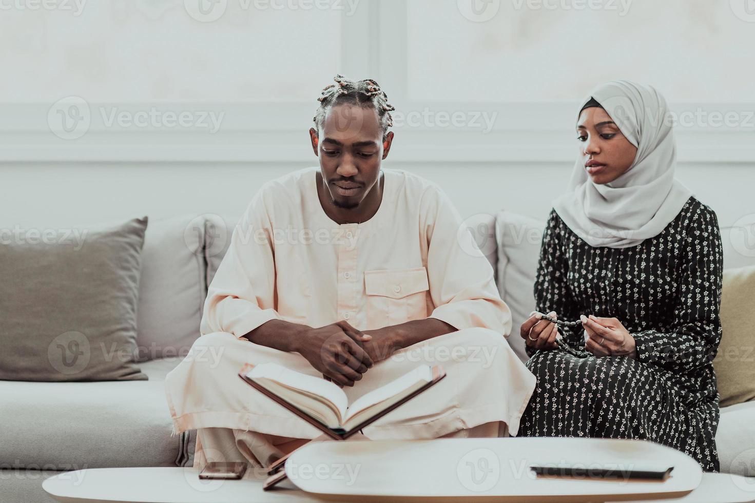 afrikansk muslim par på Hem i ramadan läsning quran järnek islam bok. foto