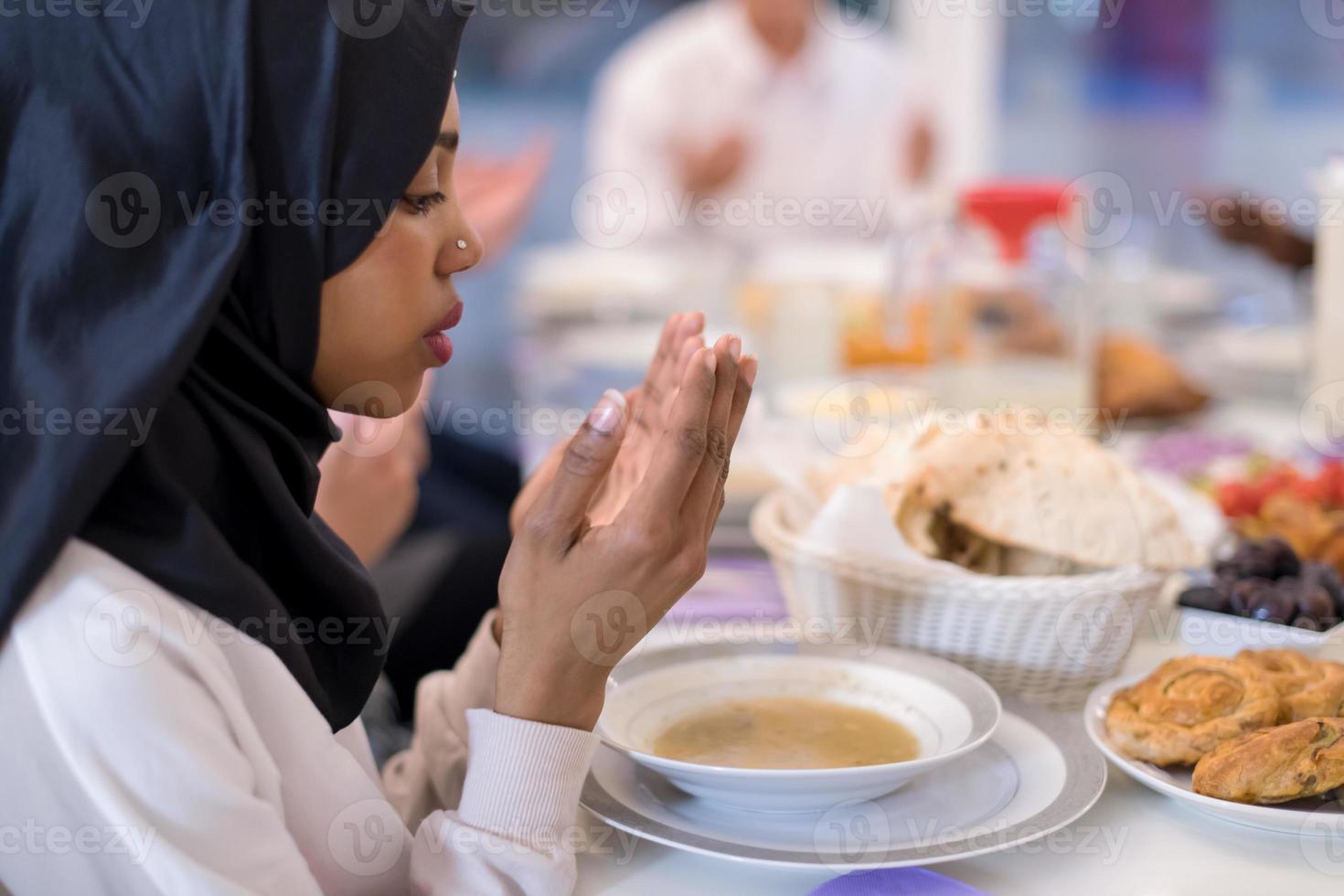 modern svart muslim kvinna bön- innan har iftar middag foto