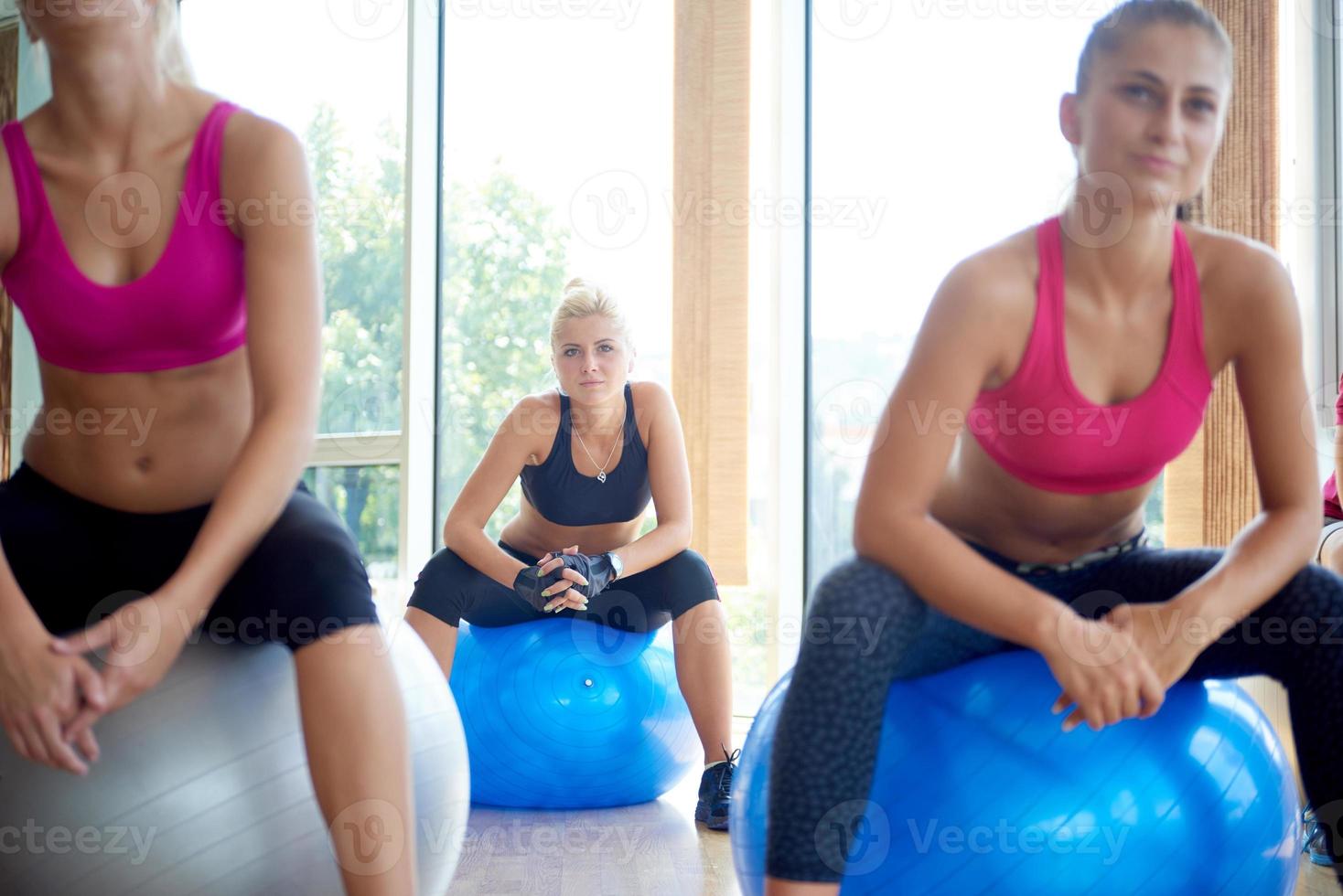 grupp av människor övning med bollar på yoga klass foto