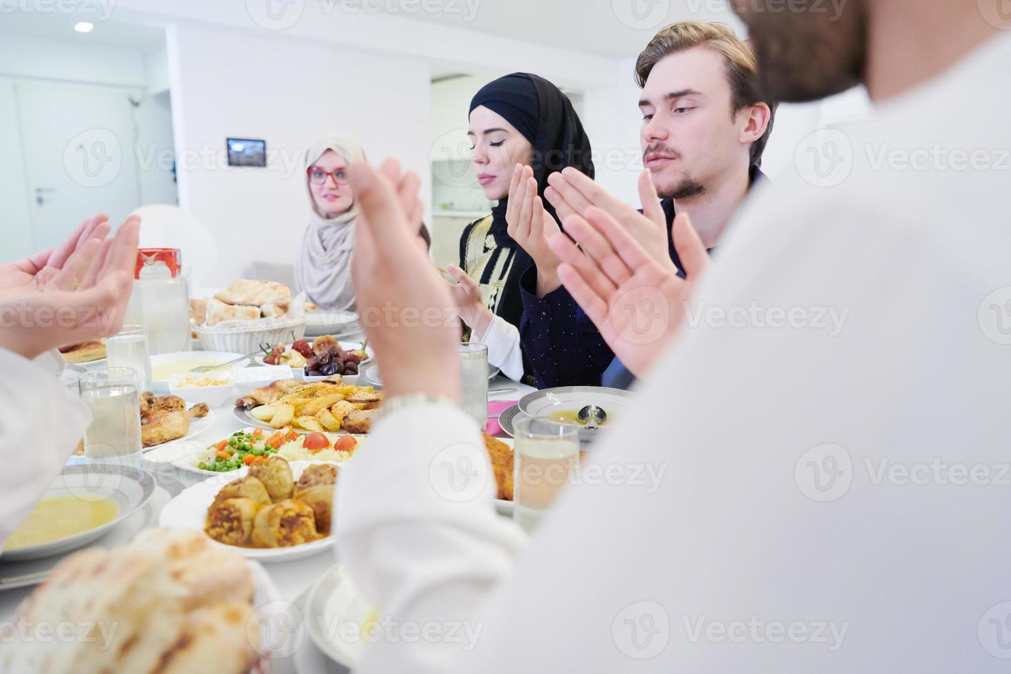 traditionell muslim familj bön- innan iftar middag foto
