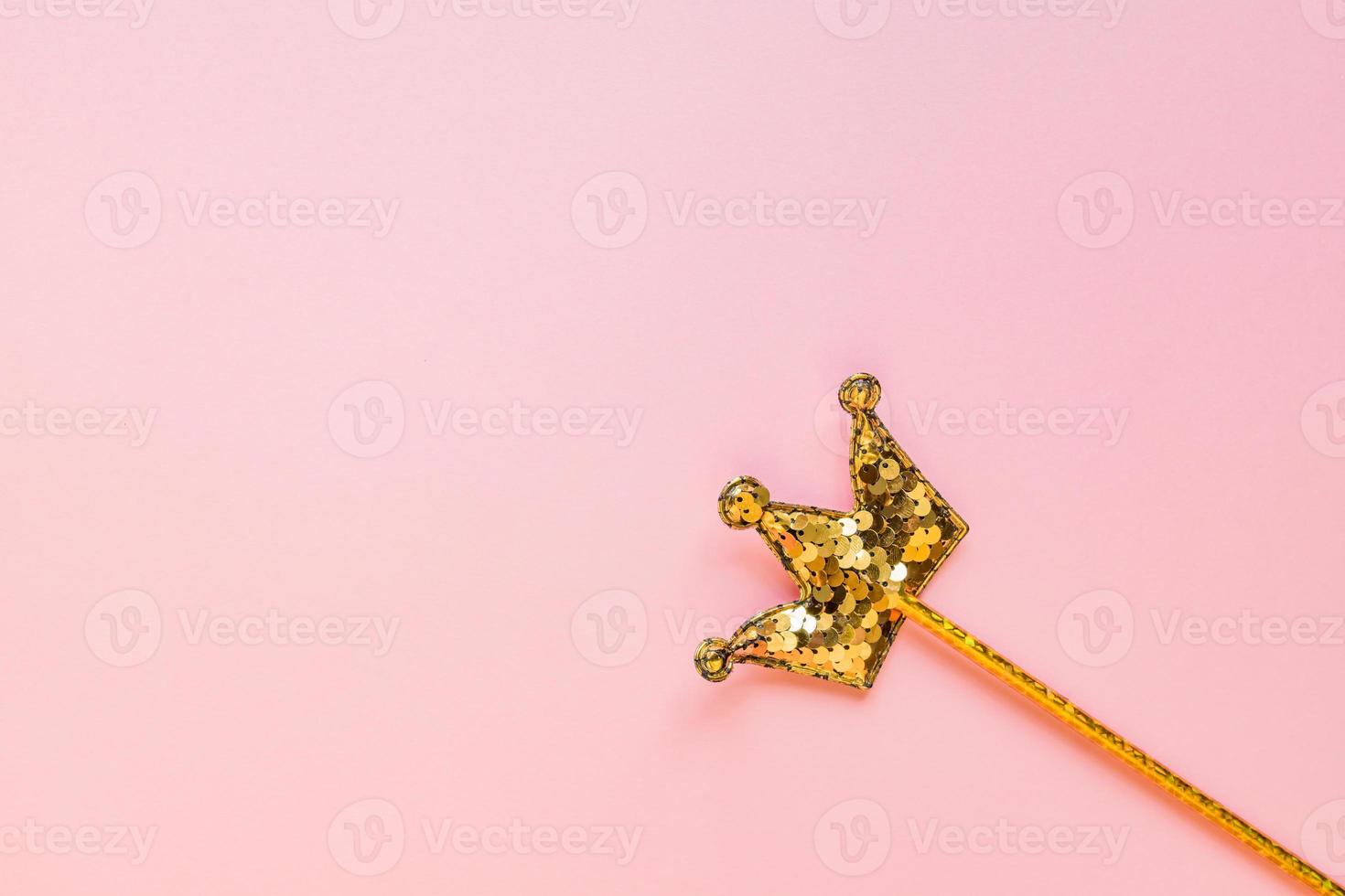 gyllene magi pinne från paljetter i krona form på pastell rosa backgeound. kreativ platt lägga i minimal stil foto