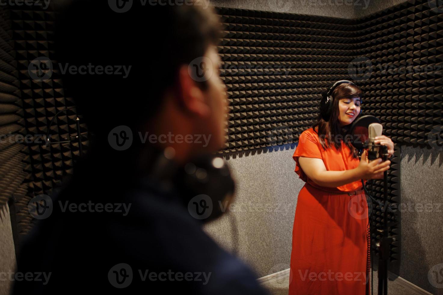 ung asiatisk duett sångare med mikrofon inspelning låt i spela in musik studio. foto