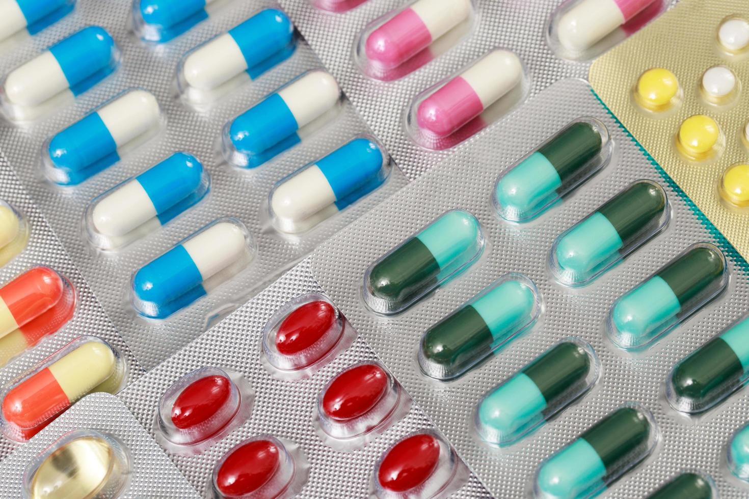 närbild läkemedel antibiotika piller medicin i blisterförpackningar. färgglada antibakteriella piller apotek bakgrund. kapsel piller medicin antimikrobiell läkemedelsresistens. läkemedelsindustri foto