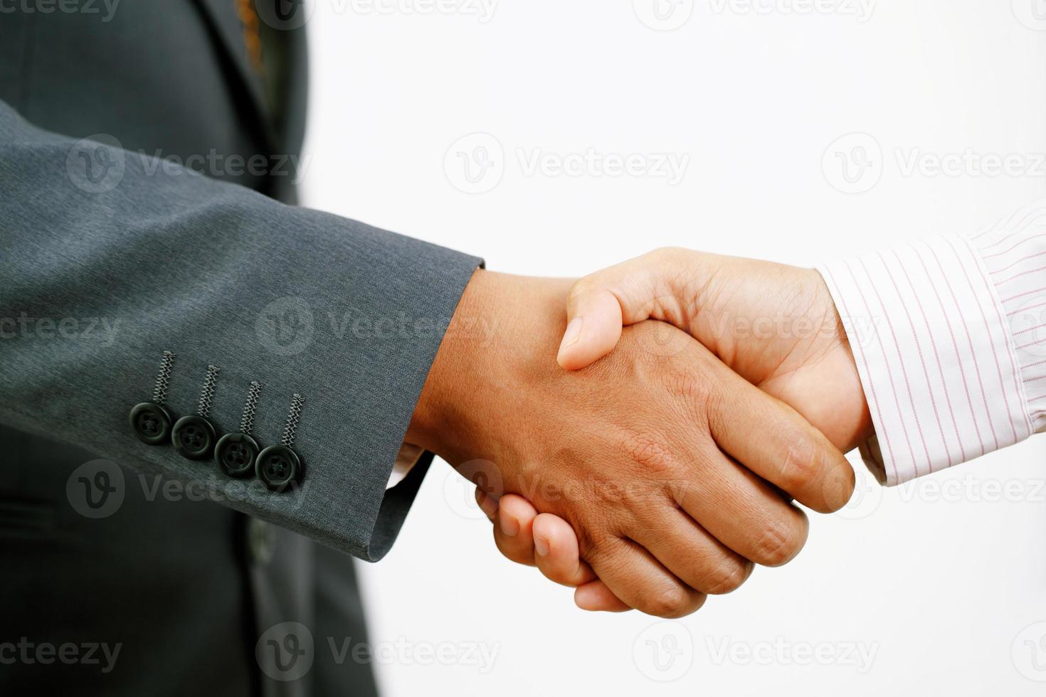 närbild av en företag hand skaka mellan två kollegor pläd skjorta foto