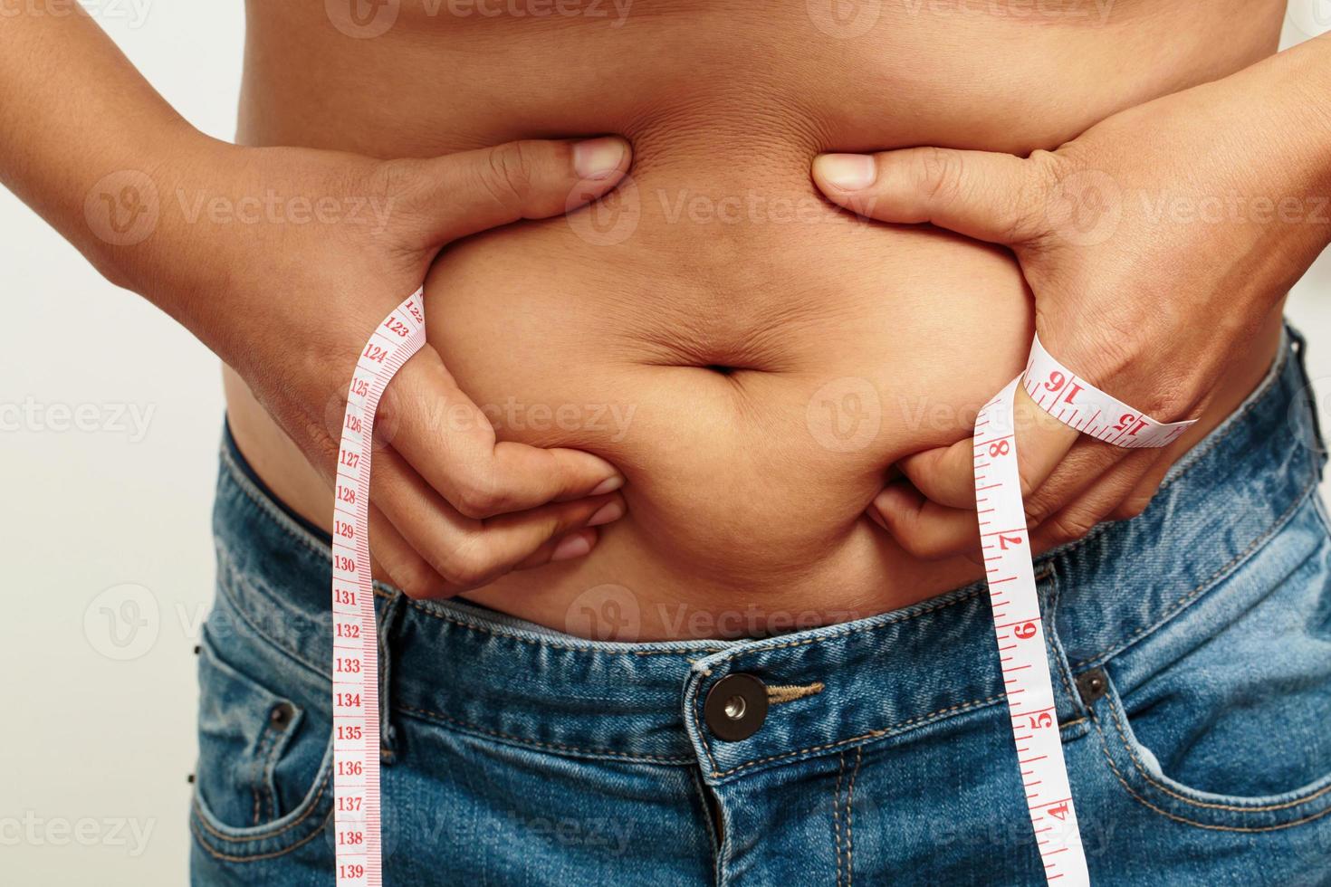 fett man kolla upp ut kropp övervikt buk hans mage med i hand mätning tejp foto