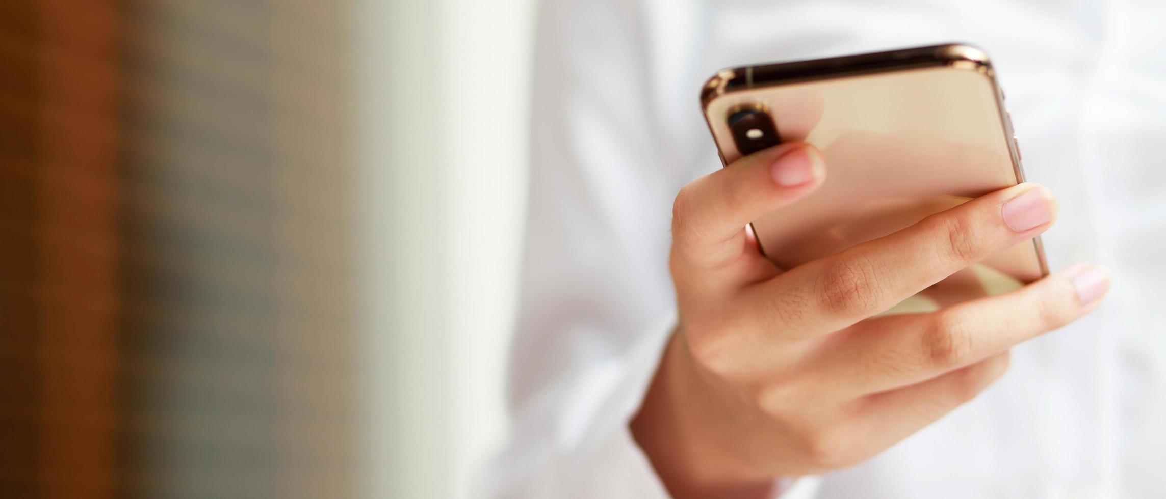 stänga upp hand ung kvinna i tittar på meddelande på mobil smart telefon under ha sönder. använder sig av cell telefoner till kommunicera i de uppkopplad värld. med tom eller tömma svart skärm foto