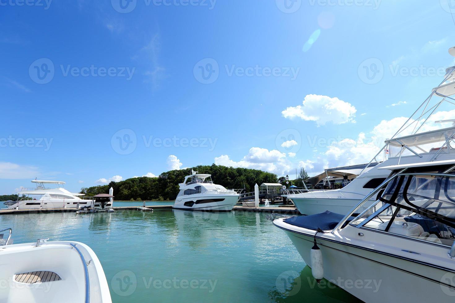 många lyx yachter flyta på kristall klar hav i marina bukt klubb, dyr privat båt stanna kvar lugna i dockning pir under sommar blå himmel grön hav foto