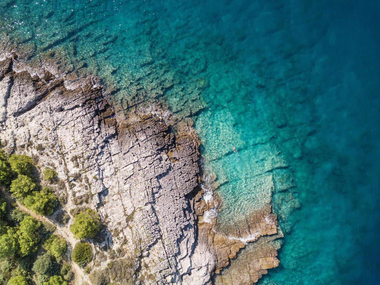 Flygfoto över solo snorklaren i turkosa kustgröna vatten foto