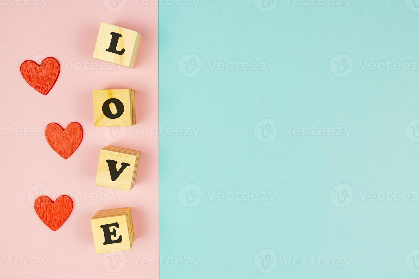 röd hjärtan och trä- kuber med text kärlek på dubbel- blå och rosa bakgrund. kreativ platt lägga med kopia Plats. festlig hälsning kort för st valentines dag. foto