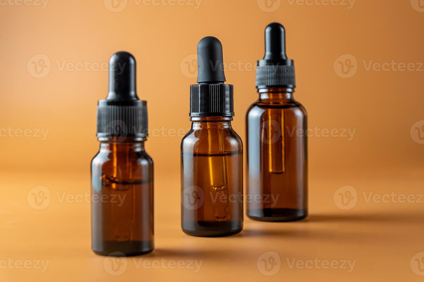 uppsättning av brun glas flaskor med grundläggande olja på en beige bakgrund. förpackning av en skönhet produkt med en pipett för alternativ medicin behandling. aromaterapi, homeopati. omärkt paket foto
