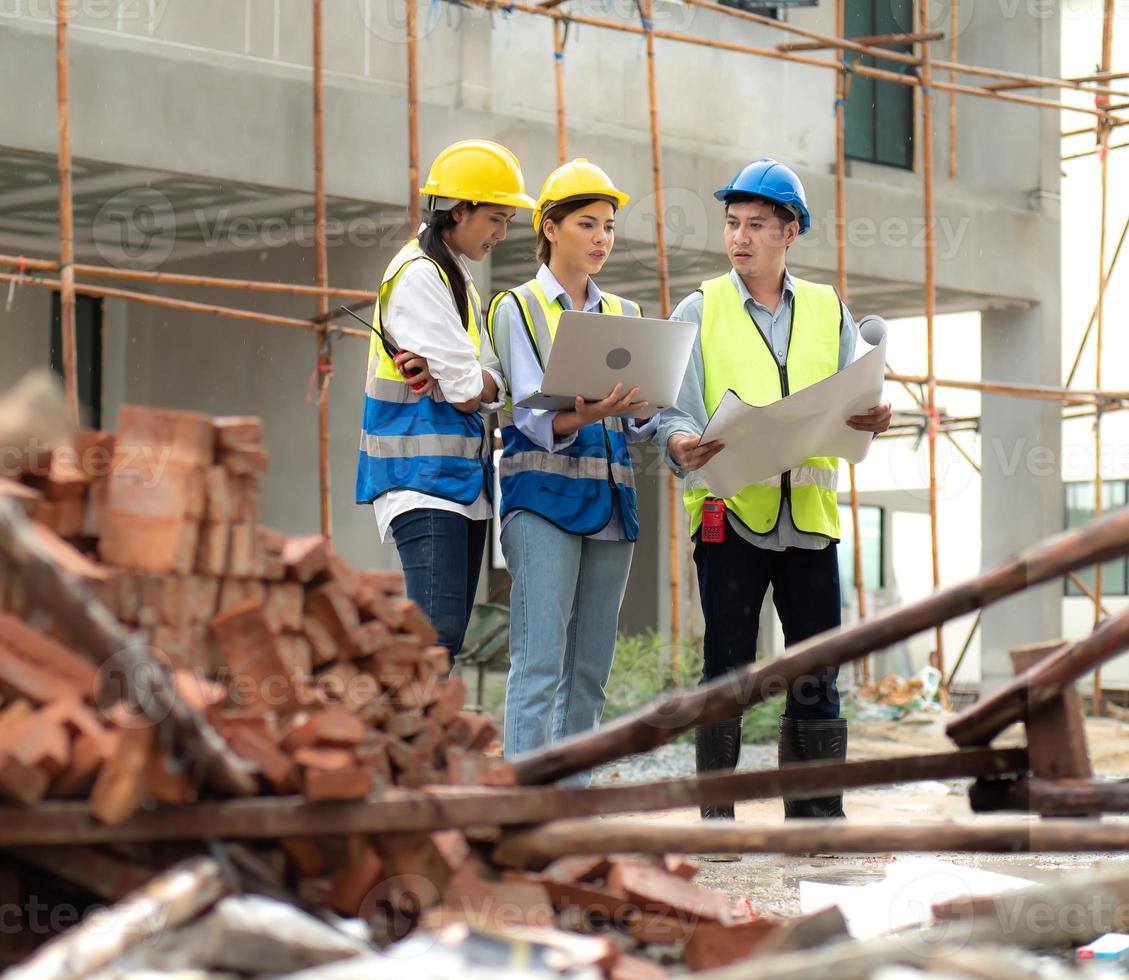 kvinna konstruktion ingenjör innehar dator bärbar dator möte med arkitekt lagarbete. raser människor grupp ha på sig säkerhet Hardhat använder sig av bärbar dator brainstorming på hus utveckling på konstruktion webbplats foto