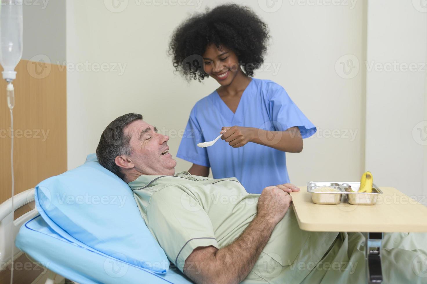 en kvinna blandad lopp sjuksköterska är arbetssätt i sjukhus , ta vård vuxen manlig patient. foto