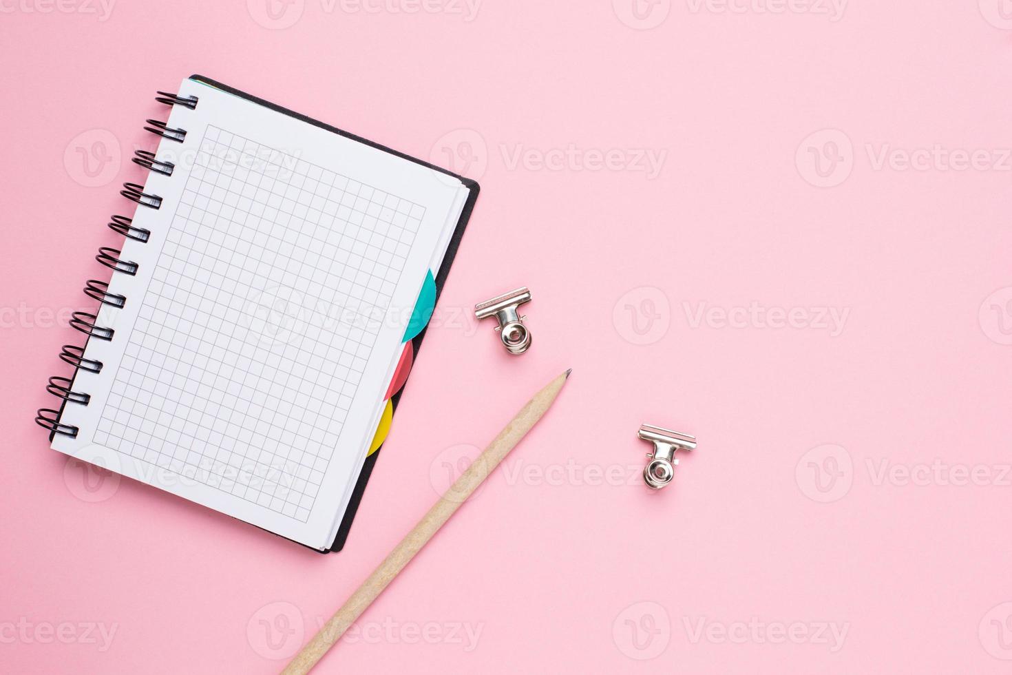 anteckningsbok i en bur med penna på en rosa bakgrund foto