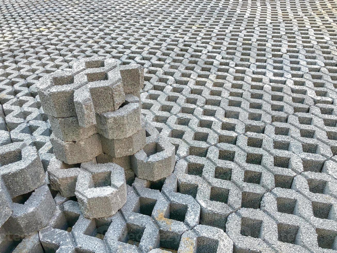 grå färg sten tegel block golv kakel med grönt gräs och sand som bakgrund eller textur. foto