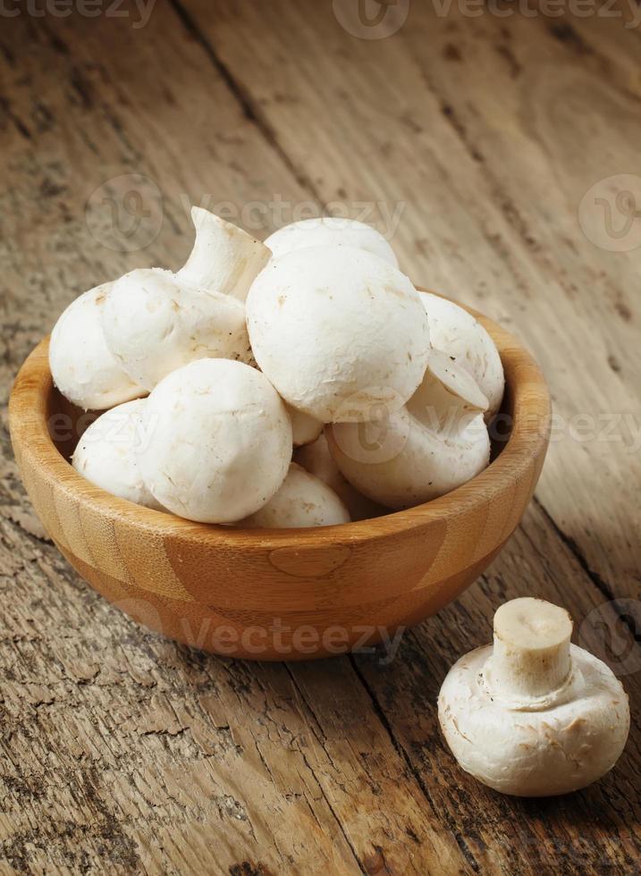 vita svampar i en skål på träbord, selektiv inriktning foto