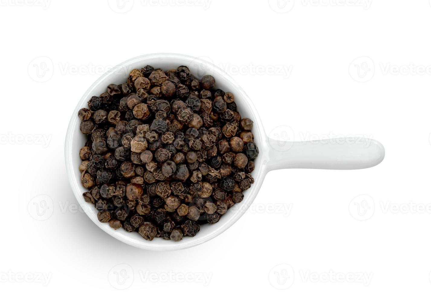 svart peppar lugg eller svart pepparkorn frön i keramisk skål isolerat på vit bakgrund. foto