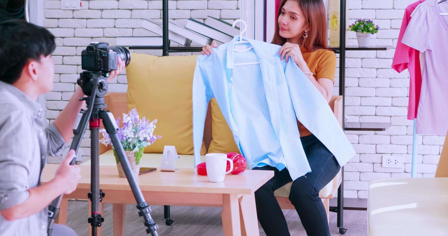 ung asiatisk par försäljning mode kläder uppkopplad förbi leva strömning med digital kamera. foto