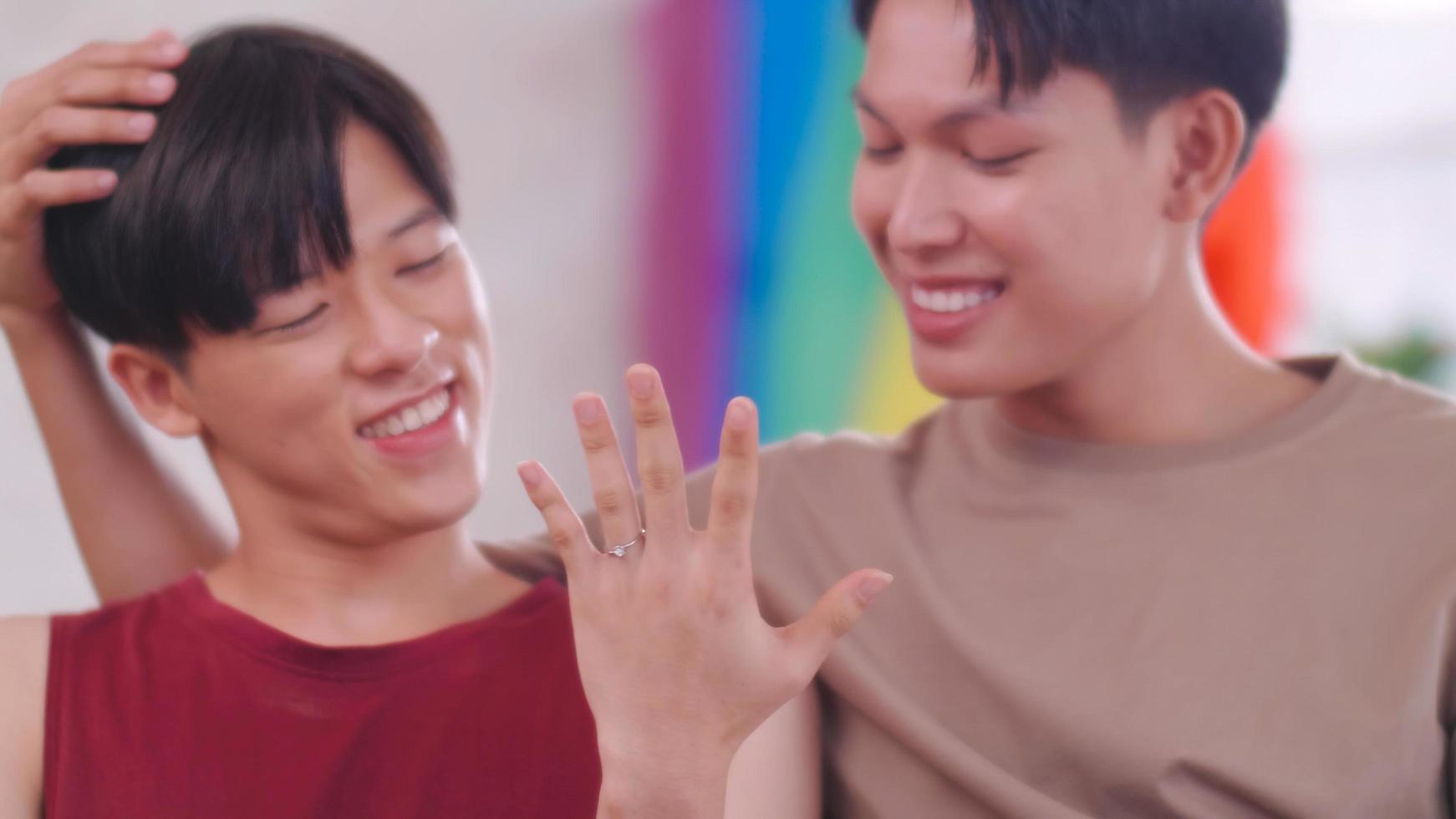 Lycklig Gay asiatisk par som visar av deras bröllop ringa. foto