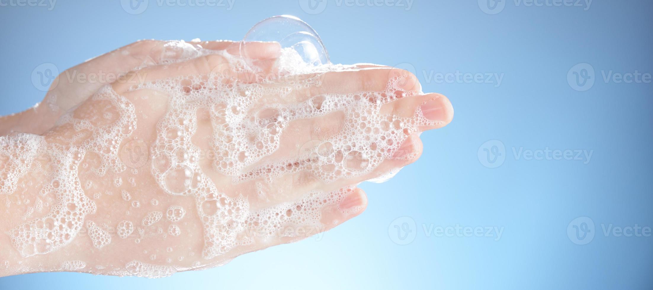 tvätta kvinnliga händer isolerad på blå bakgrund. foto