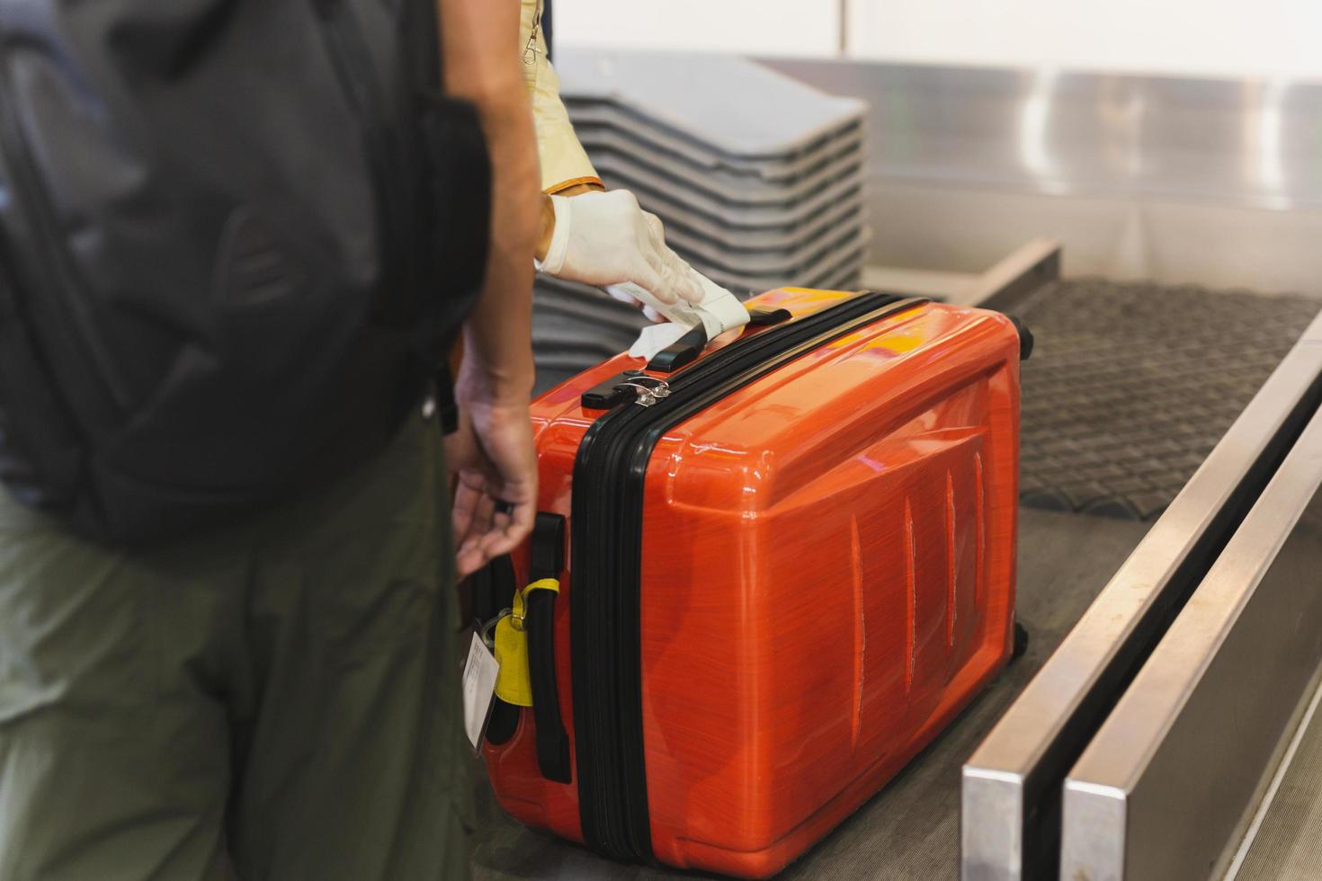 anställd sätter märka på passagerare bagage på de flygplats. foto
