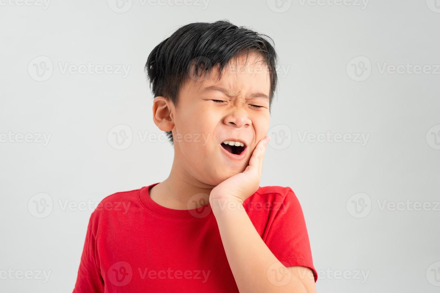 liten pojke barn ha tandvärk, tandvärk känslor stor uppblåst kind känsla bakgrund foto