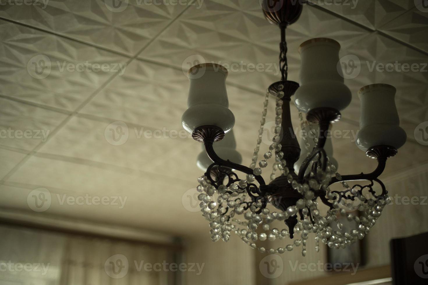 gammal kristallkrona i interiör av lägenhet. lampor i rum är av. foto