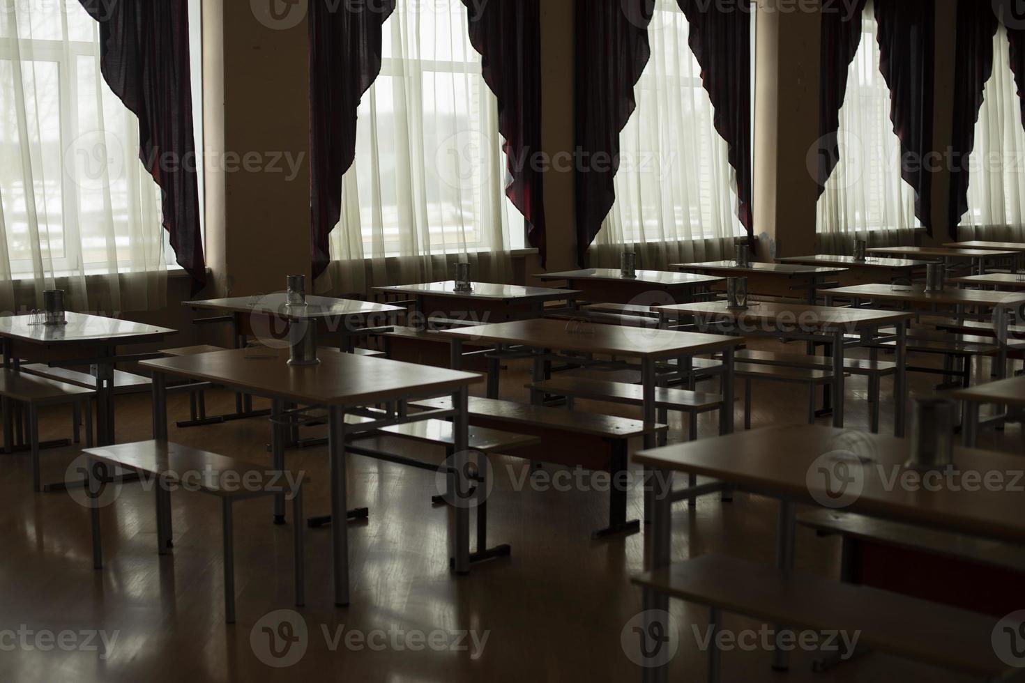 mörk hall med tabeller. gardiner på fönster. foto