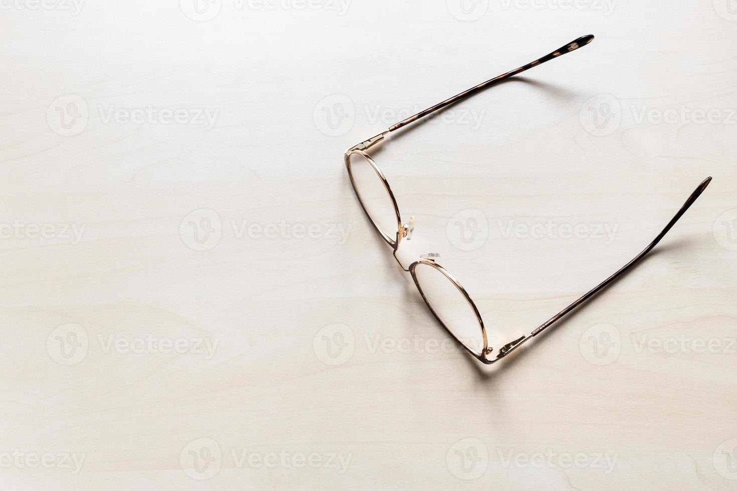 glasögon på ljus brun trä- styrelse foto