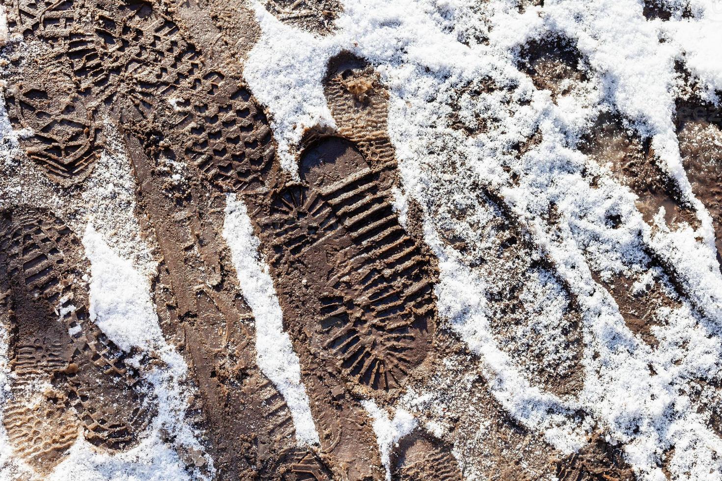 fotspår på smutsig väg täckt förbi snö foto