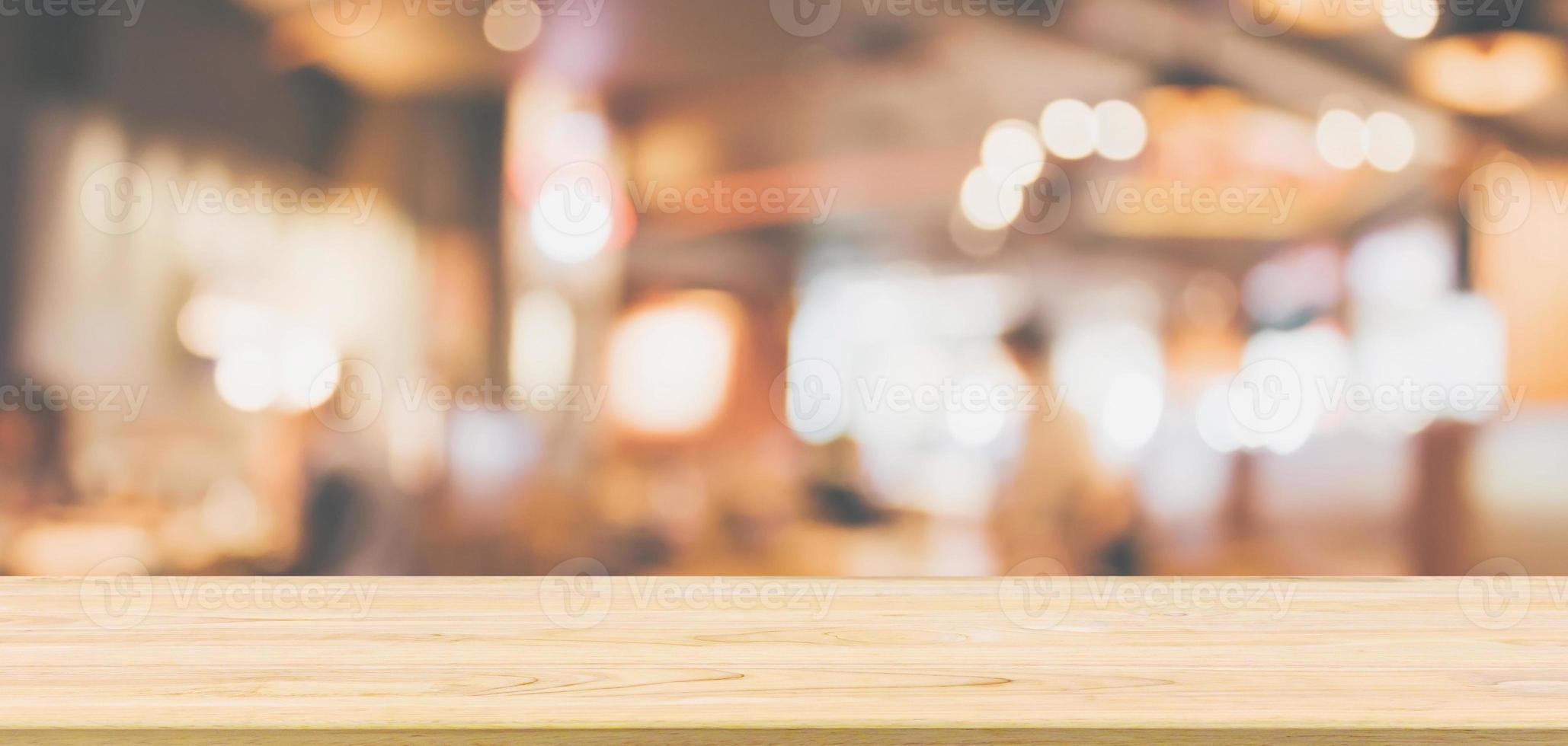 trä bordsskiva med restaurang café eller kafé interiör med människor abstrakt oskärpa bakgrund foto