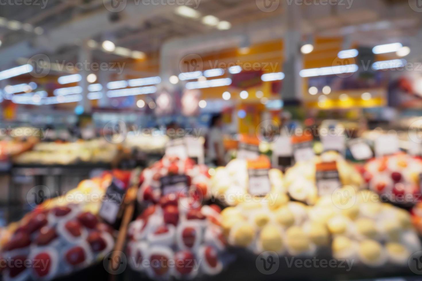 livsmedelsbutik med färsk frukt och grönsaker hyllor i stormarknad oskärpa bakgrund foto