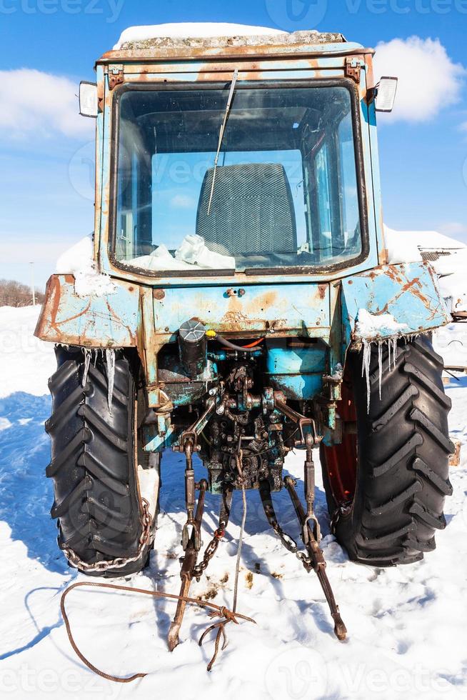 bruten traktor på snöig väg i solig vinter- dag foto