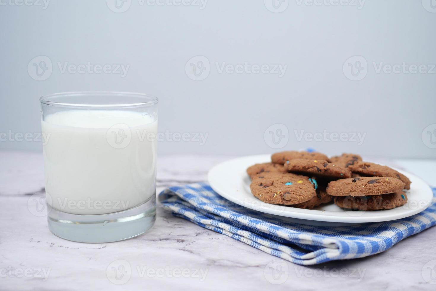 glas av mjölk och småkakor på tabell foto