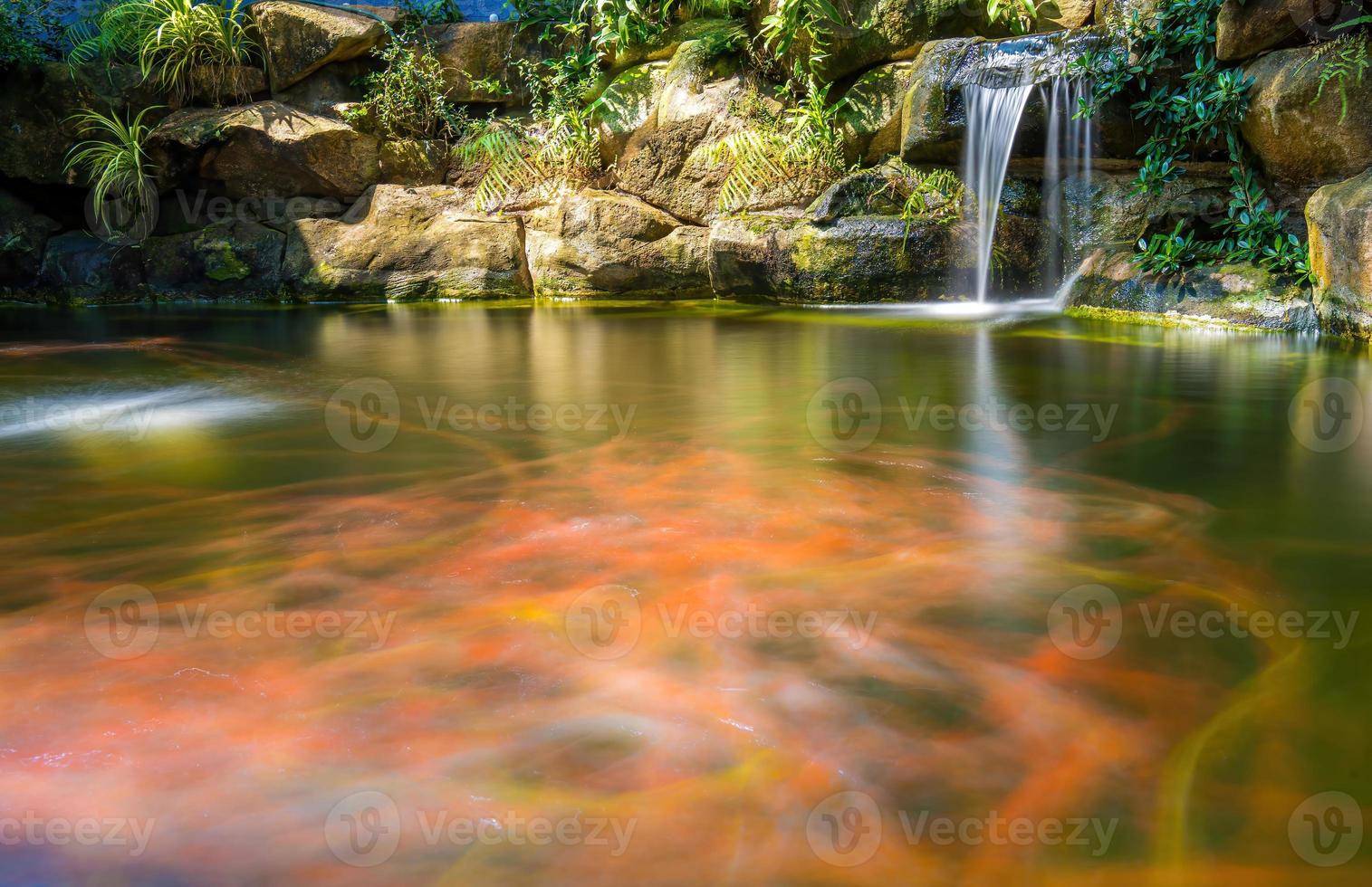 japansk trädgård vattenfall. frodig grön tropisk koi damm med vattenfall från varje sida. en frodig grön trädgård med vattenfall cascading ner de klippig stenar. zen och fredlig bakgrund. foto