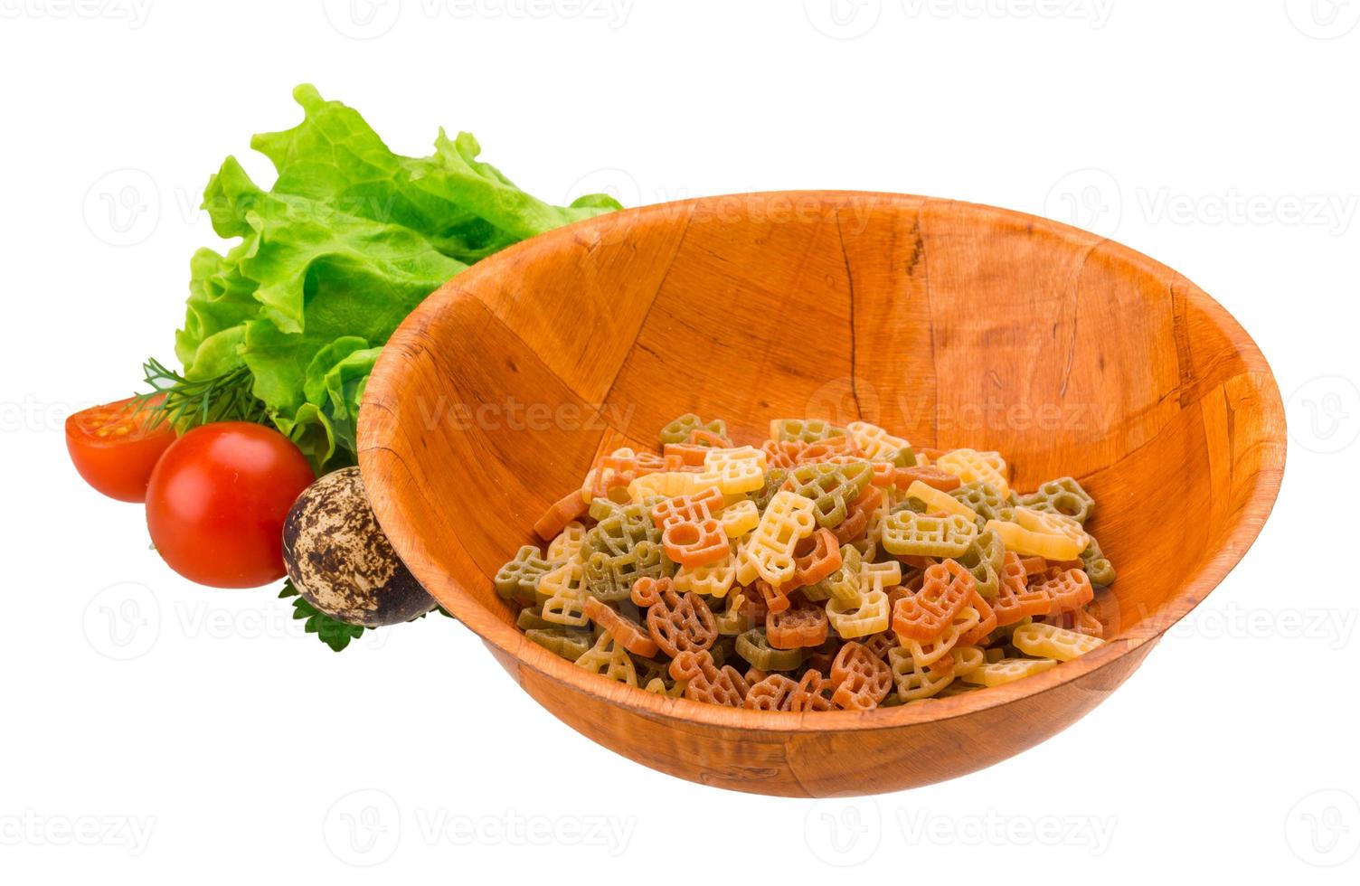 rå pasta i en skål på vit bakgrund foto