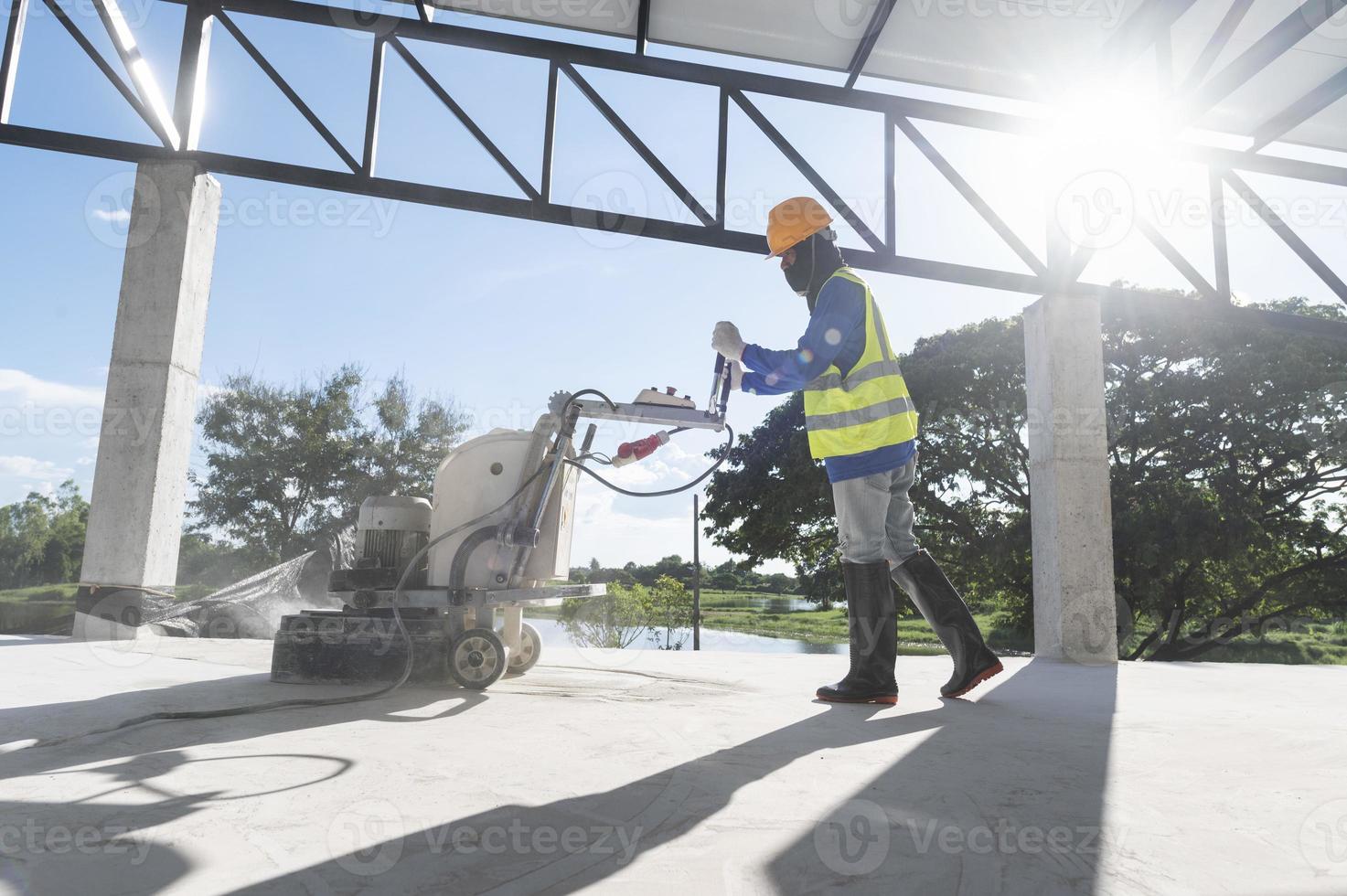 konstruktion arbetare använda sig av en maskin till putsa och Avsluta ytor eller epoxi betong på de Hem webbplats. foto