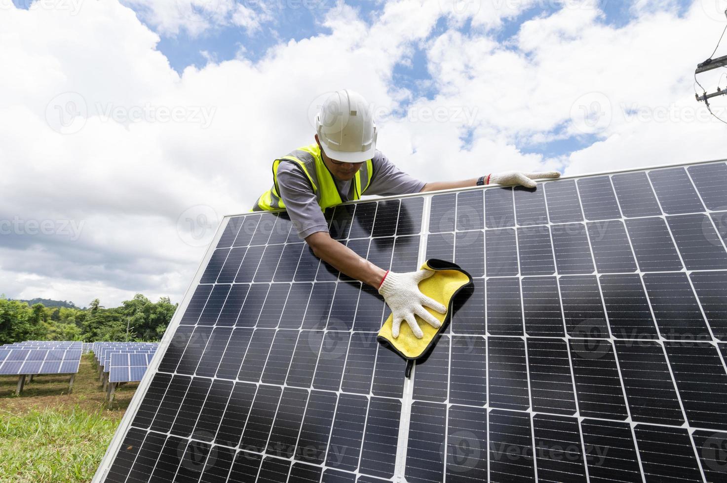 ingenjör rengöring sol- paneler hand torka de sol- panel från smuts.rengöring mini solceller som installerad bredvid foto
