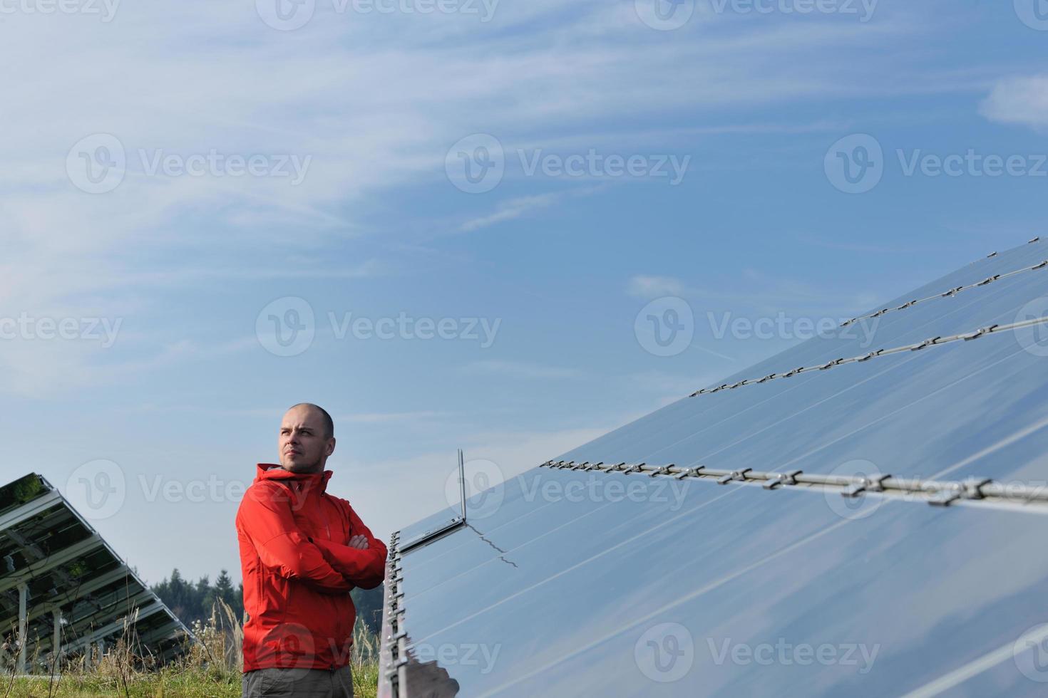 ingenjör använder sig av bärbar dator på sol- paneler växt fält foto